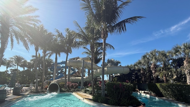 A water park with a large water slide, multiple pools, and inflatable rings. - Great reviews,Brand new,waterfront,heated pool, hot tub & beach access -14 pple  (Bonita Springs)