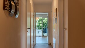 En hall som leder ut till en uteplats med utsikt över grönområden.