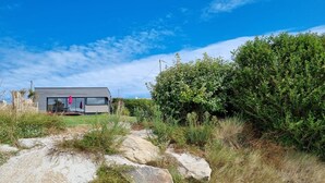 Ein modernes Haus mit flachem Dach, großen Fenstern und einer Terrassenfläche.