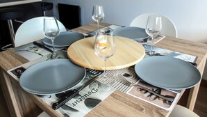 A dining table set with plates, cutlery, and wine glasses, with a candle centerpiece.