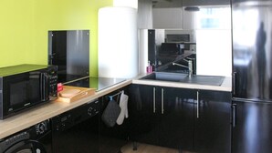 A compact kitchen with a microwave, oven, and refrigerator.