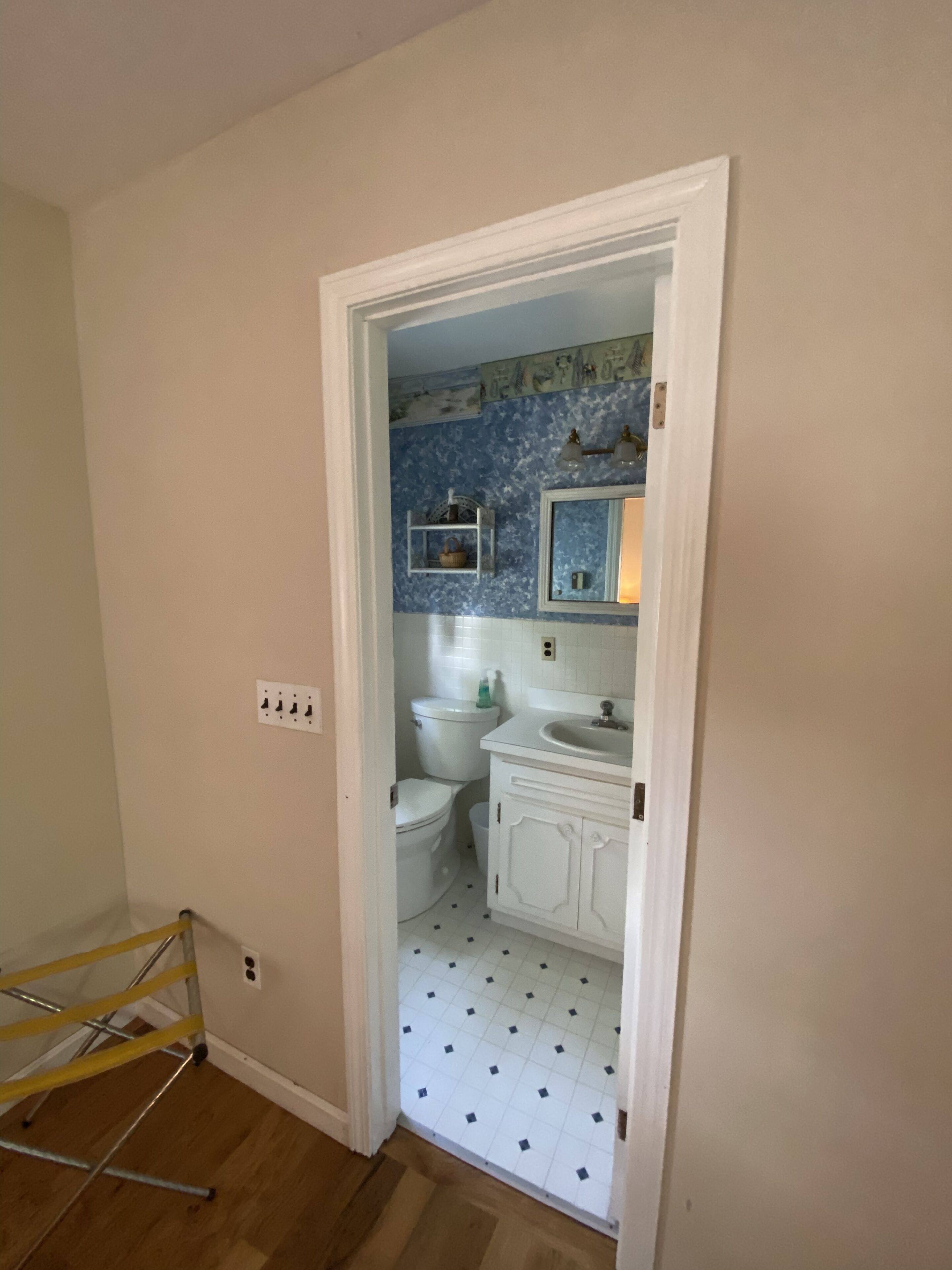 A bathroom with a white toilet, sink, and cabinet, and a blue tiled backsplash.