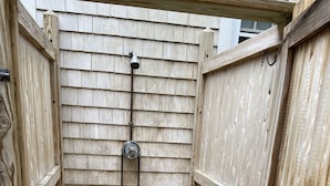 A wooden outdoor shower with a metal hose and a faucet. - Harwich home close to the beach (Harwich)
