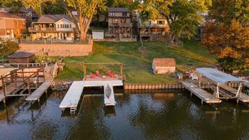 A waterfront property with docks, a grassy area, and residential buildings in the background.