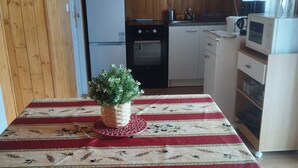 Una cocina con armarios de madera, un refrigerador, un horno y un microondas.