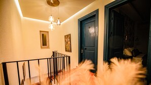 A staircase with a railing, a door, and a light fixture. - PetraAda Bozcaada (Bozcaada)