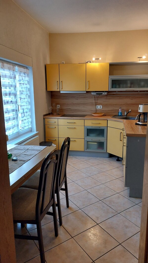 A compact kitchen with yellow cabinets, a microwave, and a sink. - Marie's "Coastal Magic" (Bentwisch)