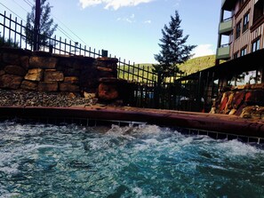 A pool area with a stone wall and a wooden fence. - Amazing location! TRUE Ski-In/Out @ Winter Park Slopeside ZML. Sleeps 9, 2BR/2BA (Winter Park)