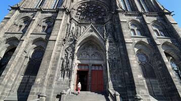 En storslået katedral med detaljeret gotisk arkitektur, kendetegnet ved høje spir, udsmykkede stenskulpturer og et markant rosetvindue.
