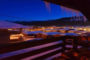 A snow-covered village with illuminated buildings and a mountain backdrop. - 30-square-meter studio with a fireplace at Resort La Foux d'Allos (La Foux d'Allos)