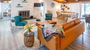 Un amplio espacio habitable con chimenea, una mesa de comedor y un sofá.