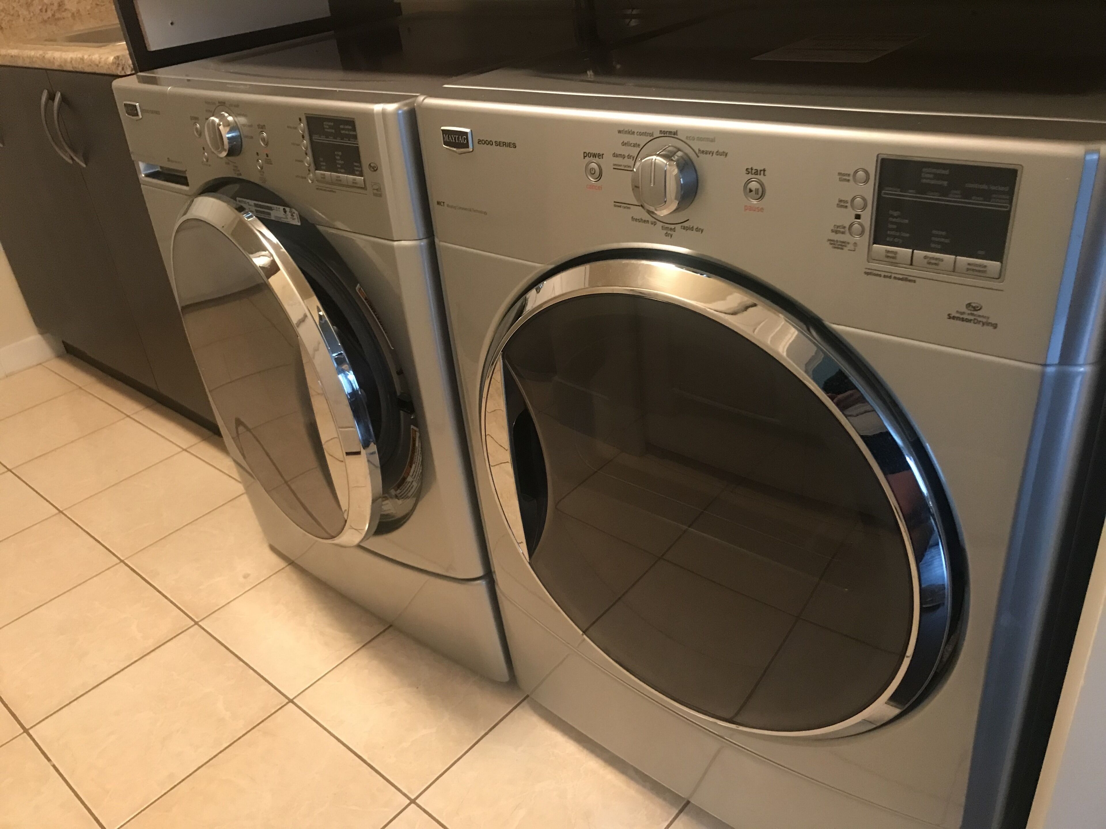A front-loading washer and dryer unit with control panels and a digital display.