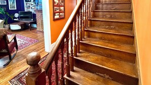 A staircase with wooden steps and a wooden handrail, leading to an upper floor. - Perfect Basecamp! 3b/3bath Historic Downtown 🏡 (Fayetteville)