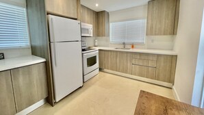 A modern kitchen with a refrigerator, oven, microwave, and sink.
