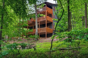 A multi-story wooden building surrounded by dense forest.