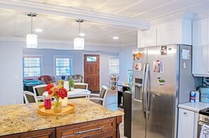 Enjoy cooking in this well-equipped kitchen with a central island, stainless steel appliances, and a dining area.