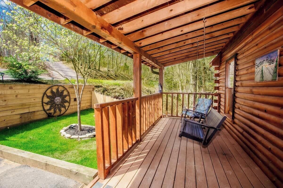 A wooden deck with a covered area, a small tree, and a chair.