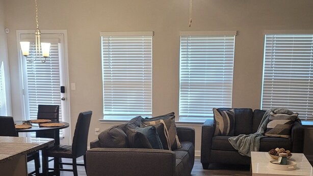Un salon moderne avec un canapé gris, une table à manger avec des chaises et un ventilateur de plafond.
