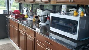 Une cuisine avec des meubles de rangement en bois, un four à micro-ondes et une cuisinière.