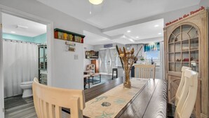A dining area with a long table, chairs, and a decorative centerpiece. - FANTASTIC 2 BR 2 Blocks to beach pool balcony (Seaside Heights)
