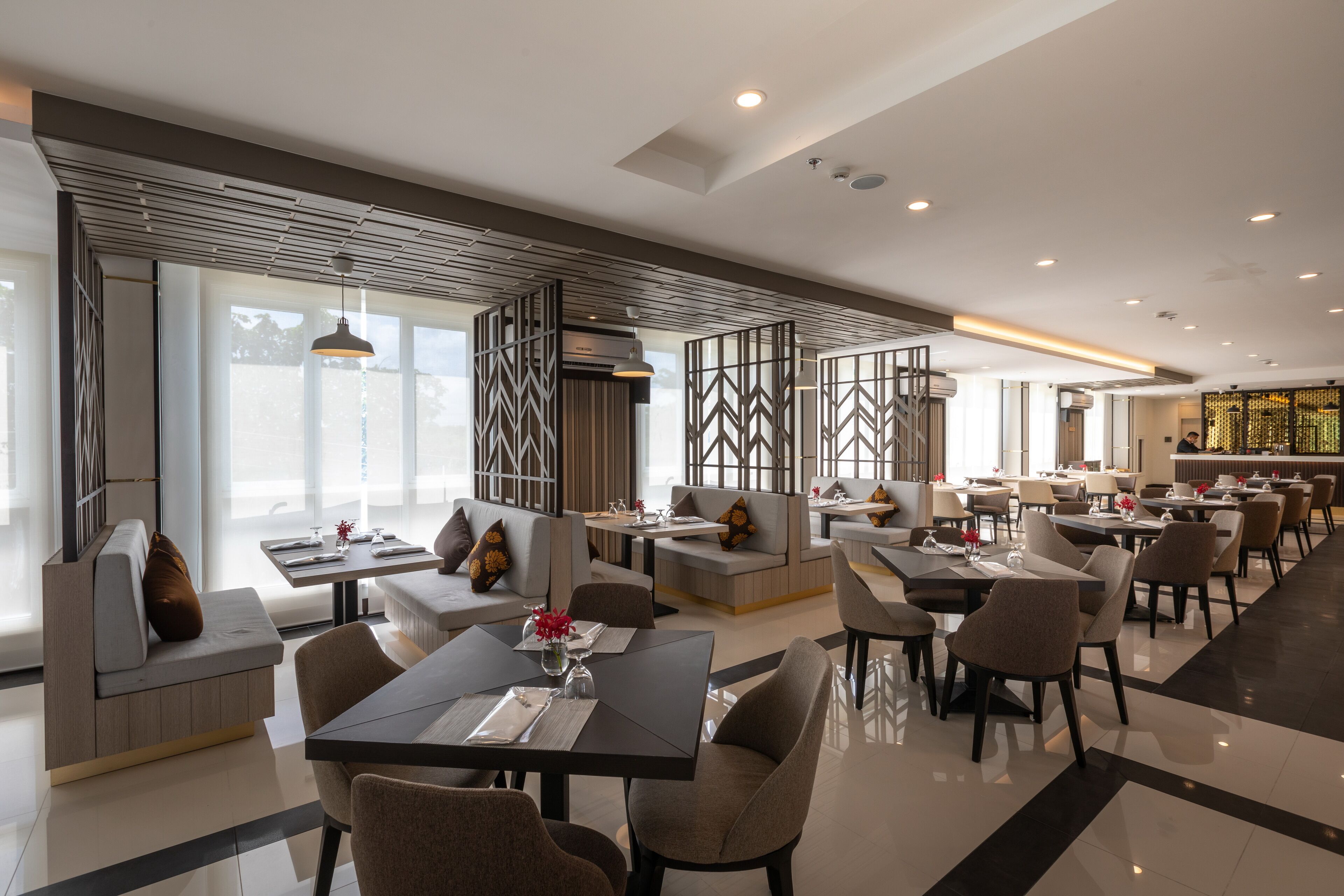A modern dining area with high tables, comfortable seating, and a view of the outdoors.