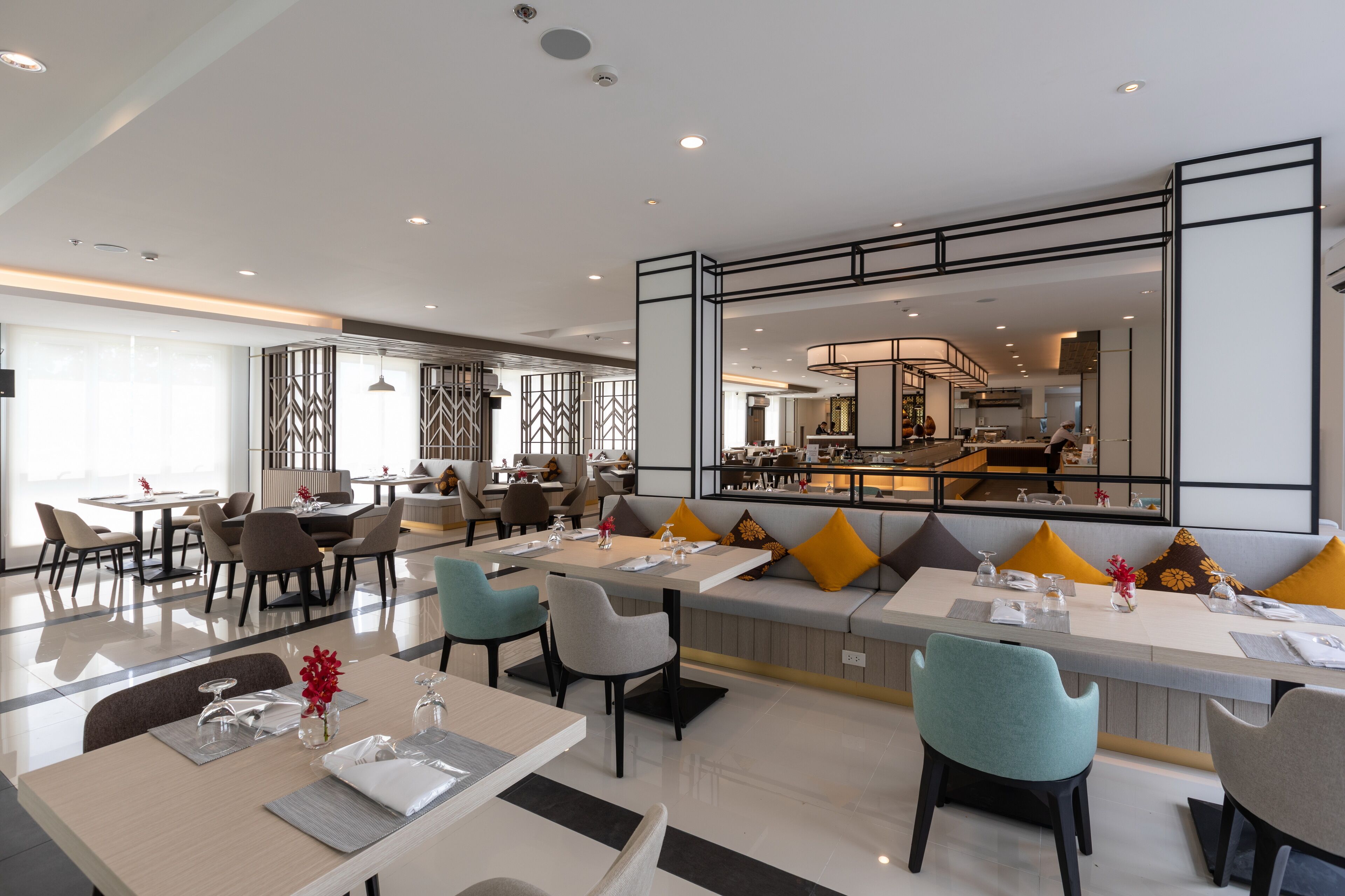 Eine moderne Hotelhalle mit einer zentralen Sitzgruppe, einer Bar und einer Rezeption.