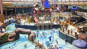 An indoor water park with multiple water slides, pools, and inflatable rafts. - Luxury Resort in Shenandoah Valley (McGaheysville)