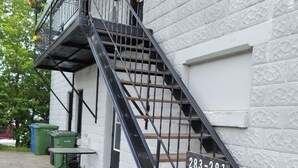 A staircase leading to a white building with a number plate '283-281'. - Vibrant apartment in the heart of the town (Edmundston)