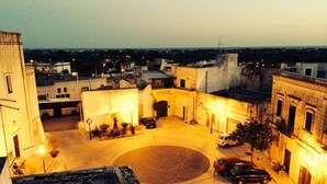 A courtyard with a circular central area, surrounded by buildings with balconies and outdoor seating. - Holiday Home" C'era una Volta" (Torricella)