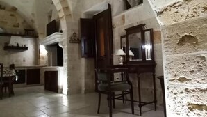 A rustic interior with stone walls, a wooden table, and a chair. - Holiday Home" C'era una Volta" (Torricella)