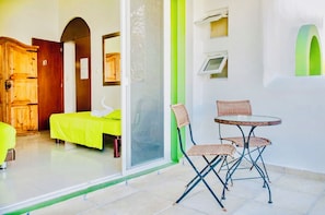 A room with a bed, a chair, a table, a wooden wardrobe, and a door with a number. - Gorgeous 22 People Villa With Pool Playacar Phase 2 (Playa del Carmen)