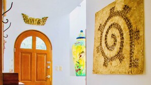 Un pasillo con una puerta de madera, una escalera y una obra de arte colgada en la pared.