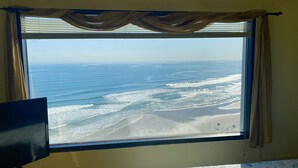 Ein Fenster mit Blick auf den Ozean und den Strand.