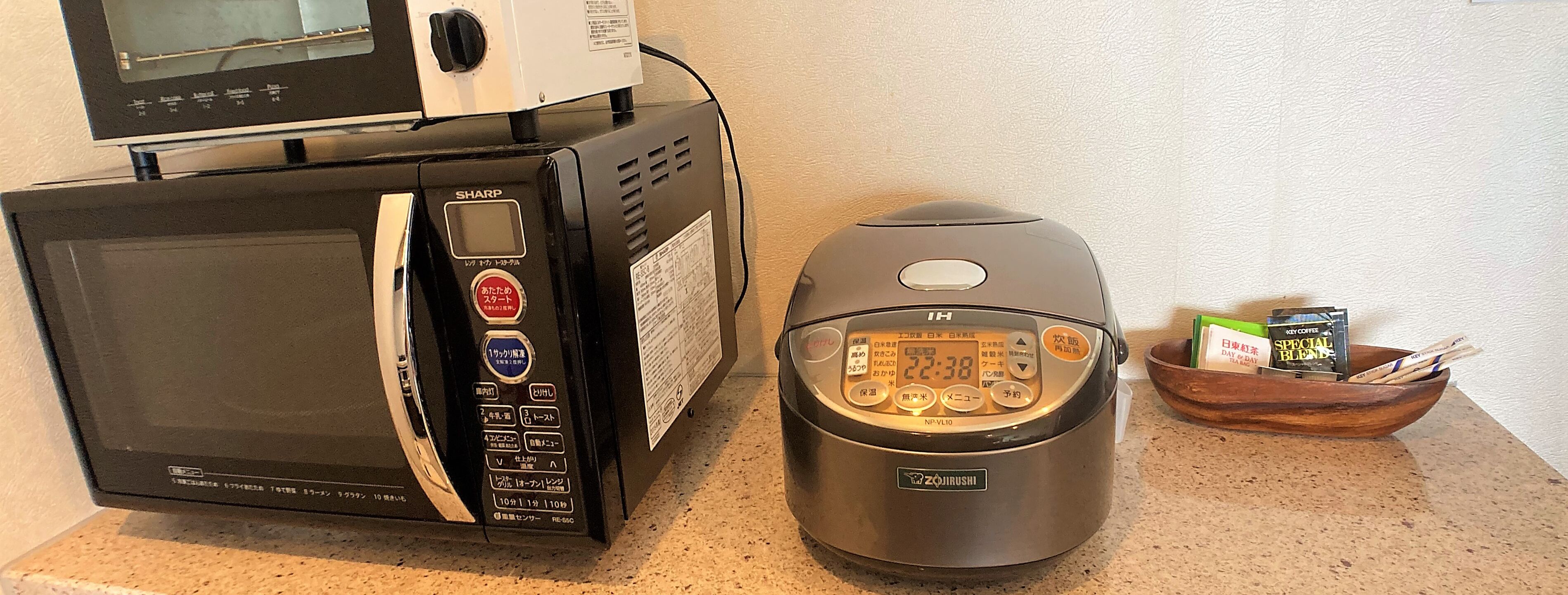 A kitchen with a microwave and a rice cooker.