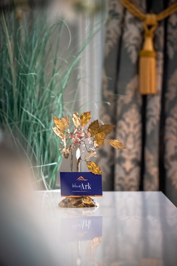A decorative plant arrangement on a reflective surface with a blue plaque labeled "blueArk". - Blue Ark Acropolis Light (Athens)