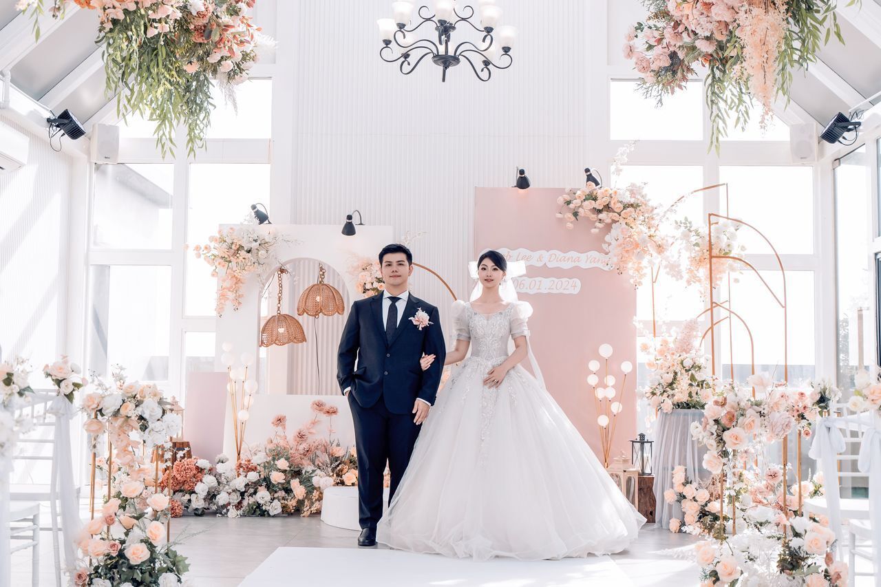 Une cérémonie de mariage où les mariés se tiennent devant une arche décorée de fleurs.