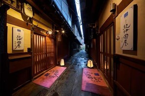 A narrow alleyway with wooden doors and traditional Japanese signage. - Oyado Kinokuniya Maruyama Machi (Nagasaki)