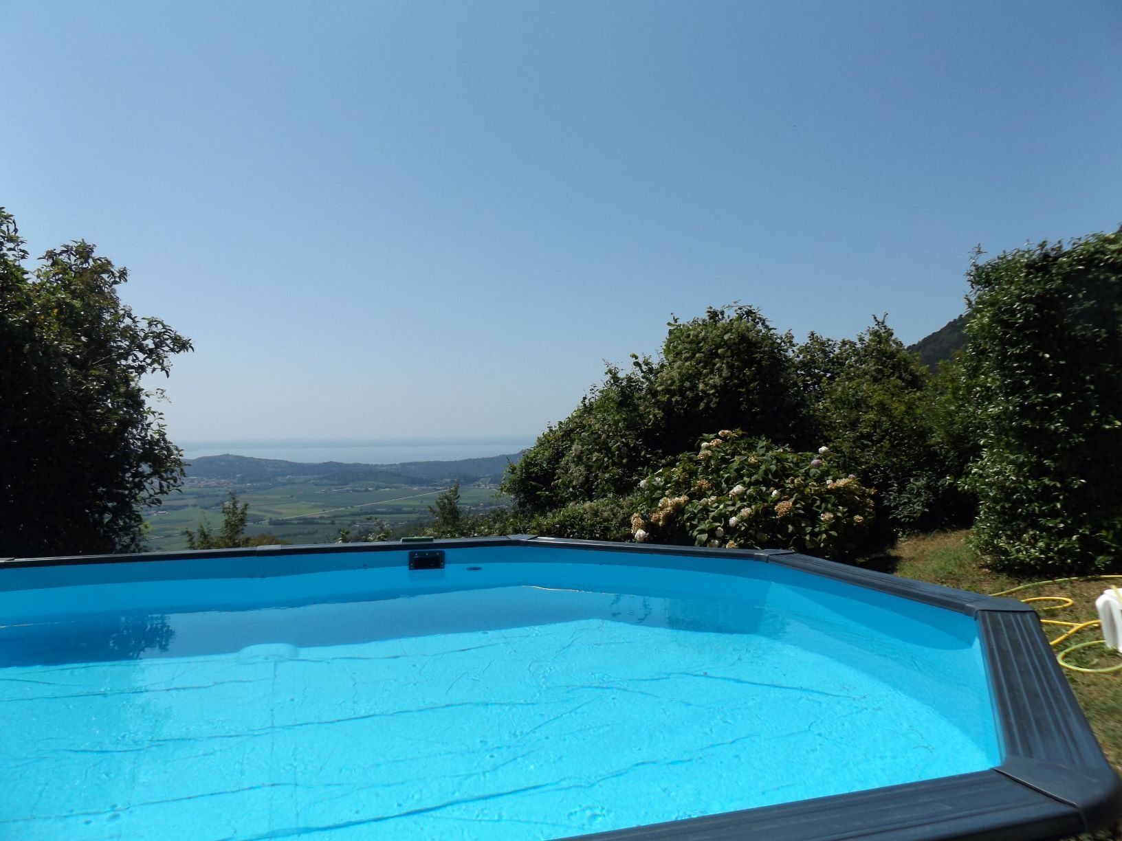 An outdoor swimming pool with a clear view of the surrounding landscape and hills.