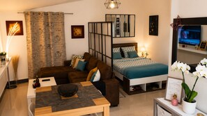 Un dormitorio moderno con cama, sofá, escritorio y televisión.