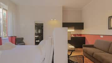 Ein Hotelzimmer mit Bett, Sofa, Esstisch und einer Küchenzeile.