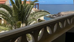 Ein Balkon mit Blick auf das Meer und einen klaren Himmel.