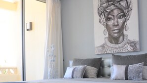 Ein Schlafzimmer mit einem großen Bett, einer Schiebetür und einem Wandbild.