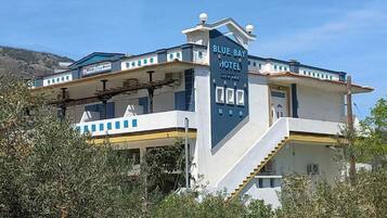 A two-story Blue Bay Hotel with a prominent entrance and a bar area.
