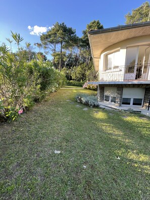 A residential property with a well-maintained lawn, a stone pathway, and a balcony with a metal railing. - Tarnos, Family Villa 4 rooms, 9 p (Tarnos)