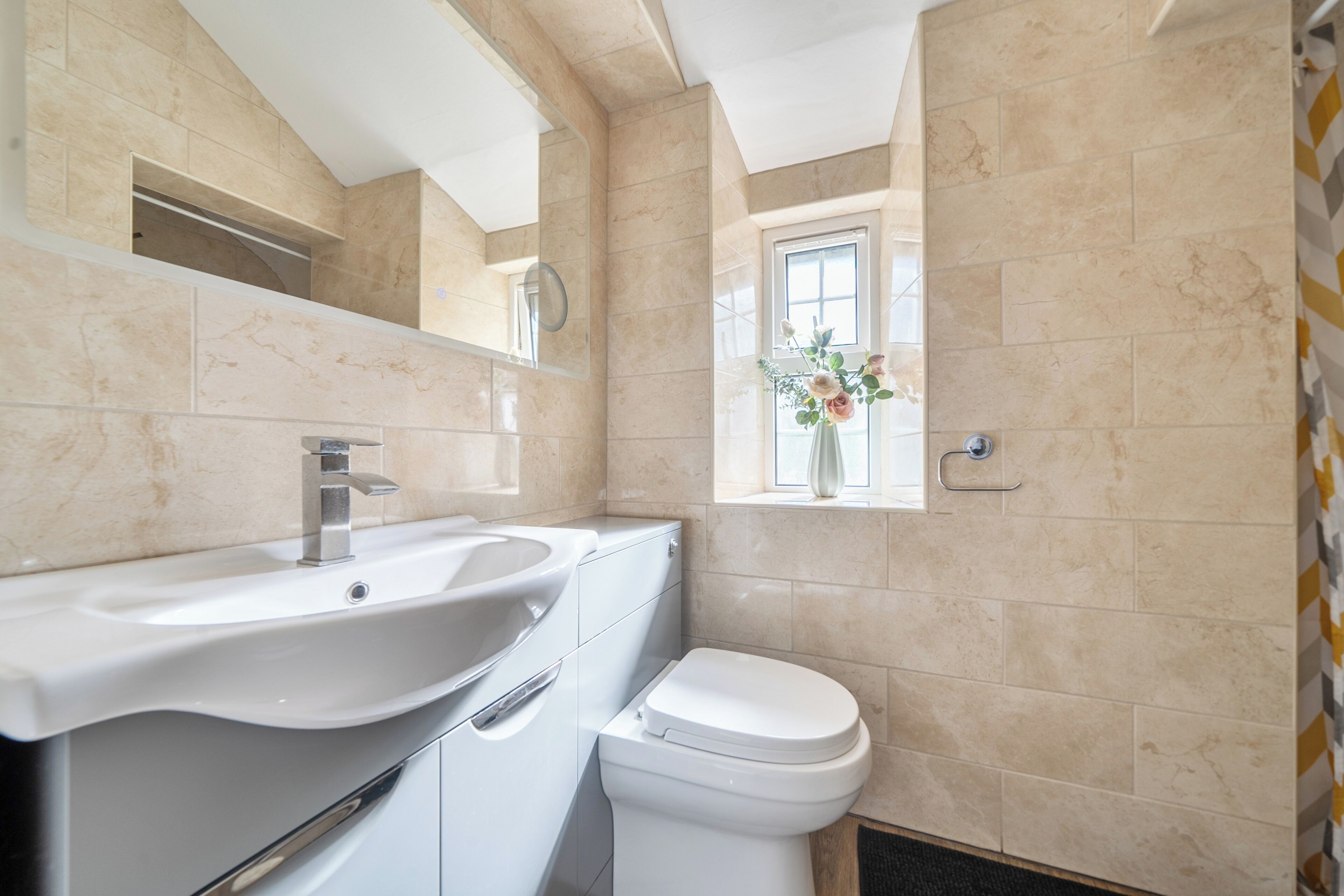 Une salle de bain avec un lavabo, des toilettes et une fenêtre donnant sur un beau paysage.