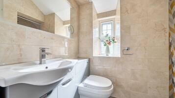 Une salle de bain avec un lavabo, des toilettes et une fenêtre donnant sur un beau paysage.