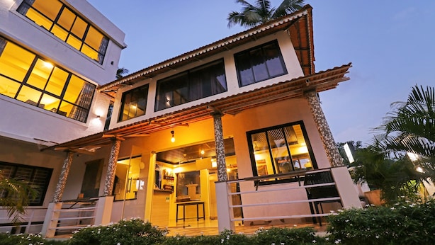 A two-story building with a balcony, large windows, and a well-lit entrance. - Itsy Hotels Morjim Pride (Morjim)