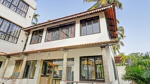 A two-story building with a balcony, large windows, and a tiled roof. - Itsy Hotels Morjim Pride (Morjim)