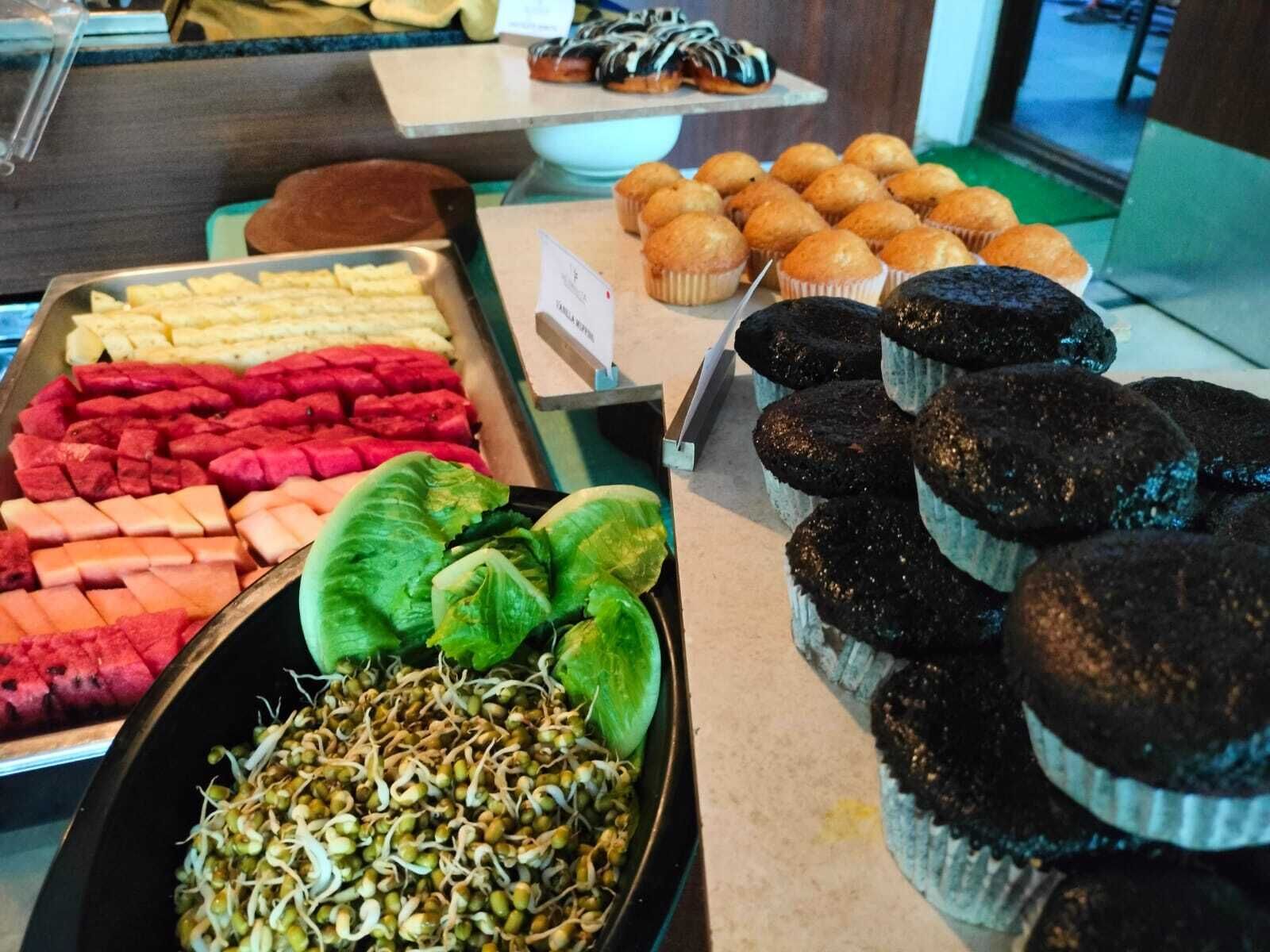 A buffet with various food items including fruits, vegetables, and baked goods.
