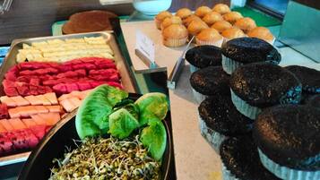 A buffet with various food items including fruits, vegetables, and baked goods.